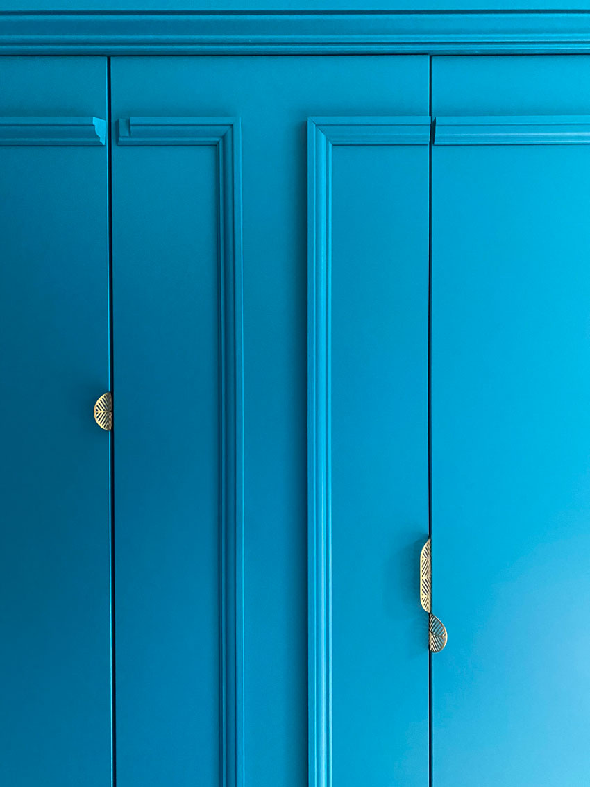 Detail of the storage doors in the wall panelling in deep aquamarine.